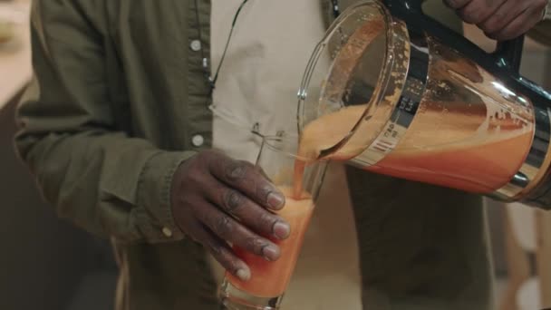 Naklápění Záběry Stárnoucího Černocha Nalévání Pití Čerstvě Vyrobené Mrkev Smoothie — Stock video