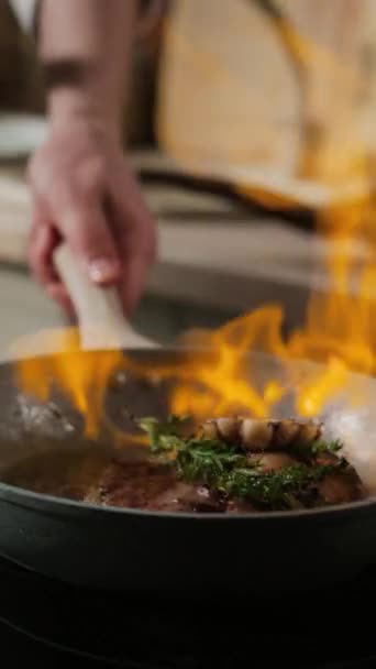 火のフライパンで牛肉ステーキを調理する認識できない男性シェフの垂直クロップショット — ストック動画