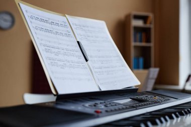 Müzik sınıfında piyanoda müzik çalmak için nota kağıdını kapat