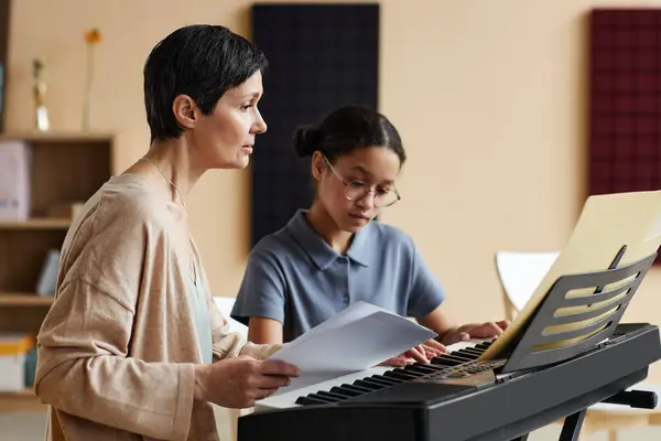 Učitelka Hudby Učí Poznámky Školačka Zatímco Ona Učí Hrát Klavír — Stock fotografie