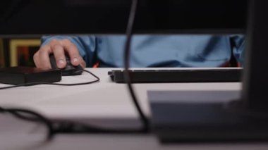 Geceleri evde bilgisayar oyunu oynarken oyun faresi ve klavye kullanarak tanınamayan oyuncunun kırpılmış görüntüsü