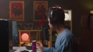 Yan görünüm, çift ırklı genç bir çocuğun kulaklıkla oynadığı video. Gece vakti apartman dairesinde kişisel bilgisayarında birinci şahıs nişancı oyunu.