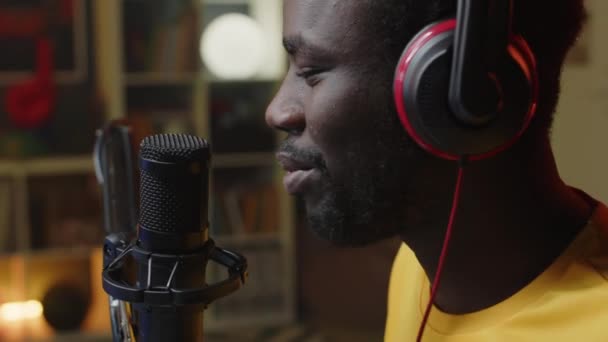 Μέτριο Κοντινό Πλάνο Του Νεαρού Μαύρου Άντρα Μιλώντας Στο Μικρόφωνο — Αρχείο Βίντεο