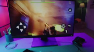 Gece vakti neon ışıklı odada birinci şahıs nişancı pc oyunu oynarken oyun faresi ve klavye kullanarak tanınmayan oyuncunun el bilgisayarı POV 'unu sallamak