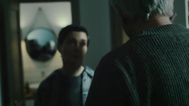 Elle çekilen resimde, kasvetli ve soğuk bir dairede kavga ederken birbirleriyle toksik ilişki içinde olan ve duygusal olarak el ele tutuşan olgun, beyaz bir çift görülüyor.
