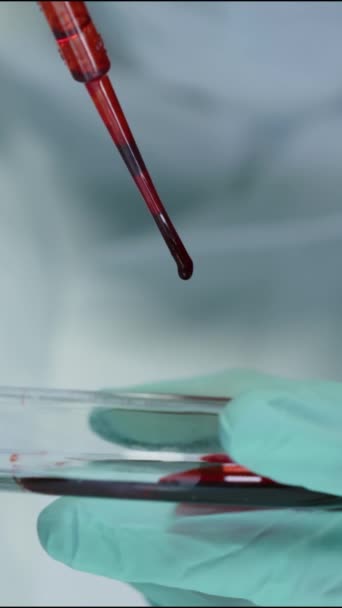 在培养皿上滴注浓红色液体时 用吸盘进行无法辨认的科学家垂直闭塞实验 — 图库视频影像
