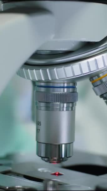 Vertikální Detailní Záběr Nerozpoznatelného Mikrobiologa Rukavicích Otáčejících Objektivními Objektivy Mikroskopu — Stock video