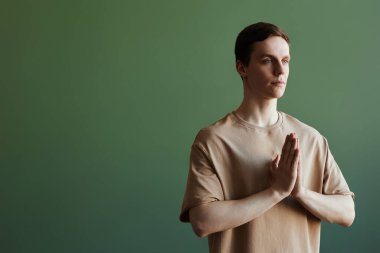 Asgari bel portresi. Yogi adam yeşile karşı meditasyon yapıyor ve fotokopi alanıyla başka yere bakıyor.