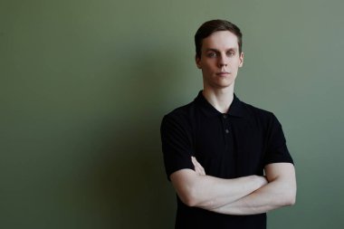 Kendine güvenen genç adamın yeşil alana bakan minimum portresi, kopyalama alanı