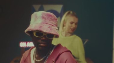 Canlı y2k kıyafetleri içinde moda öğeleriyle hip hop dansı yapan genç, şık, çok ırklı dansçıların orta yavaşlığı.