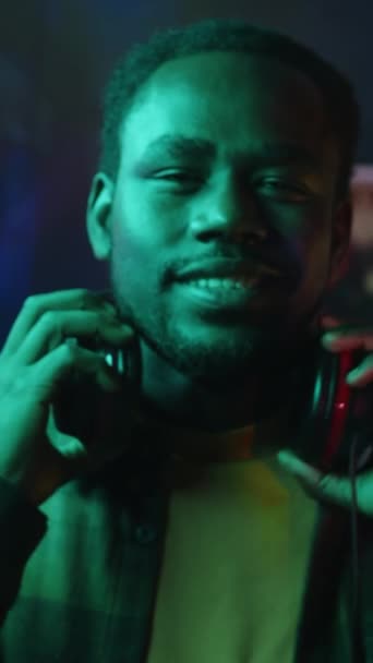 Kareli Tişörtlü Gülümseyen Siyahi Erkek Oyuncunun Karanlık Neon Işıklı Odada — Stok video