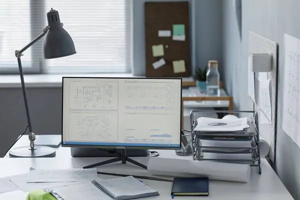 Background image of engineers workplace in office with plans on computer screen, copy space