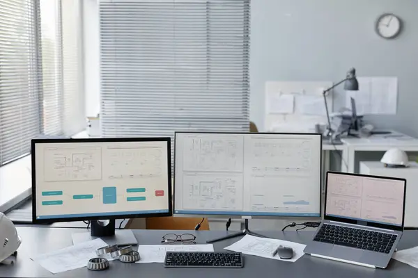 Background image of engineers workplace in office with plans and blueprints on multiple computer screens, copy space
