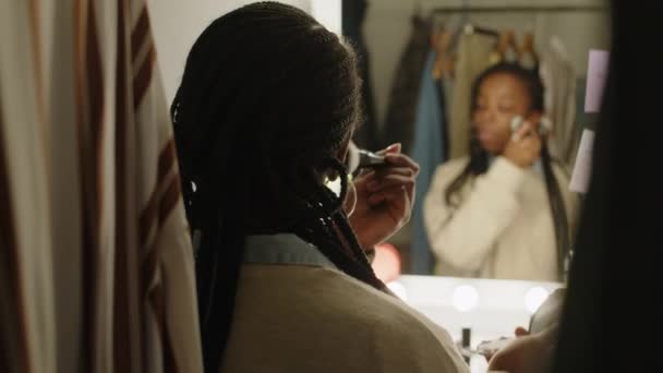 年轻的黑人女影星的背景图 她用灯泡看着后视镜 在准备演出时化妆 — 图库视频影像
