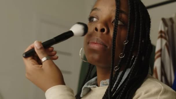 在更衣室内用刷子在镜子前化妆的年轻黑发女人的中等特写 — 图库视频影像