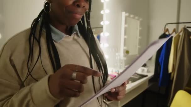 Plan Moyen Jeune Femme Noire Tressée Lisant Révisant Matériel Écrit — Video