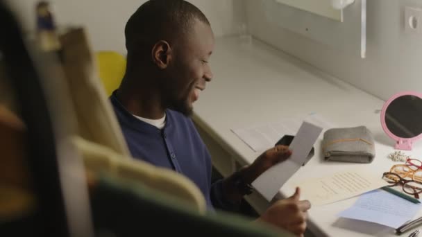 Νεαρός Χαρούμενος Μαύρος Άνδρας Διαβάζει Γράμματα Θαυμαστών Ενώ Κάθεται Στην — Αρχείο Βίντεο
