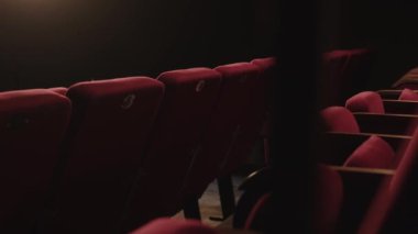 Düşük ışıkta boş kırmızı tiyatro koltuklarından kimse vurulmaz.