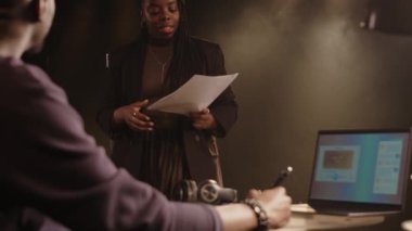 Düşük ışıkta amatör tiyatroda konser programını tartışan iki komedyenin orta boy fotoğrafı.