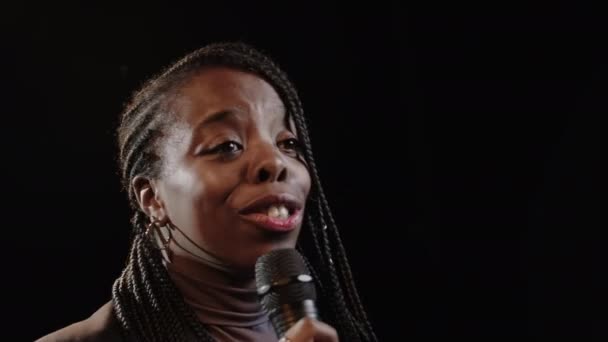 Грудь Молодой Чернокожей Женщины Плетеной Прической Стоящей Микрофоном Темной Сцене — стоковое видео