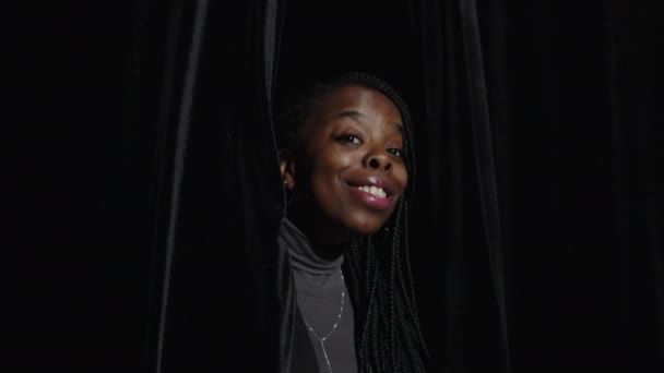 Sahnede Ipek Siyah Perdelerden Dışarı Bakarken Kameraya Gülümseyen Neşeli Genç — Stok video