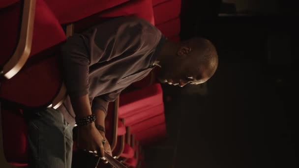 Вертикальный Средний Снимок Молодого Чернокожего Человека Сидящего Сиденье Красного Театра — стоковое видео