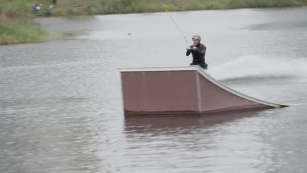 ケーブルパークの湖で男性サーファーのウェイクボードのフルショットを追跡 — ストック動画