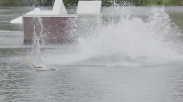 ケーブルパークでのトレーニング中にウェイクボードから落ちる白人成人の男性サーファーのスローモード — ストック動画
