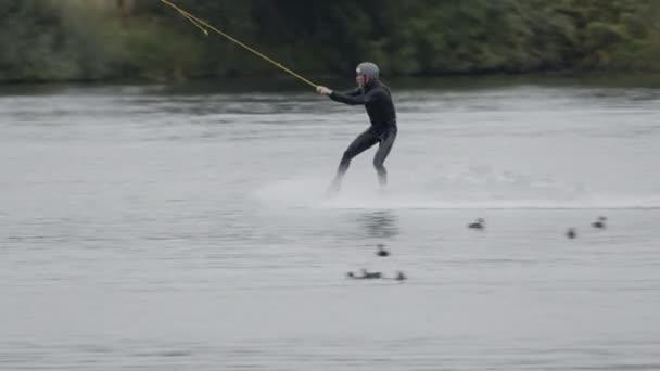 極端なウォータースポーツを実践するケーブルパークで水上およびスライダーに乗るプロのウェイクボードサーファーの追跡ショット — ストック動画
