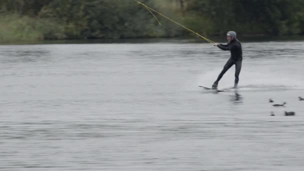 ケーブルパークでトリックを練習しながらスライダーから水に落ちる男性のウェイクボードサーファーの全長スローモ — ストック動画