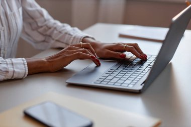 Klavyede yazan zarif kadın ellerine odaklanmış dizüstü bilgisayar kullanan tanınmayan siyahi kadının yan görüntüsü