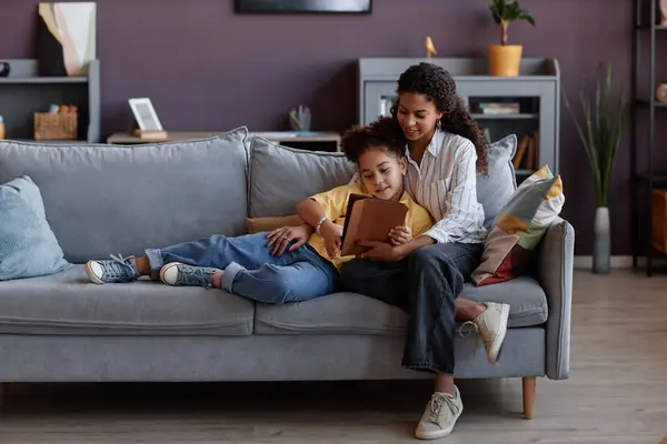 爱的母亲和女儿在家里沙发上放松的时候 一起用数码平板电脑全长的肖像 复制空间 — 图库照片