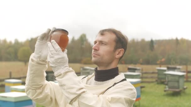 白种人男性养蜂人身着防护服 头戴蜂蜜罐相机的胸部慢速肖像 — 图库视频影像