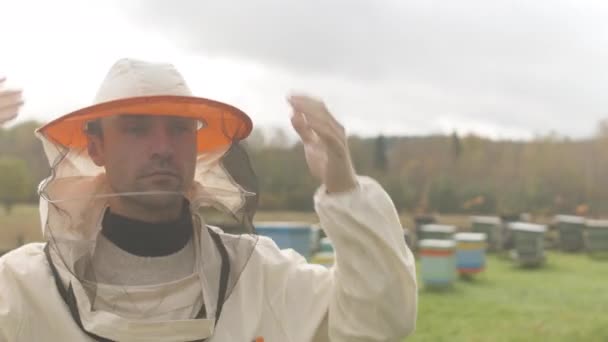 Beyaz Erkek Arı Yetiştiricisinin Peçeli Eldivenli Koruyucu Şapkasını Taktığı Orta — Stok video