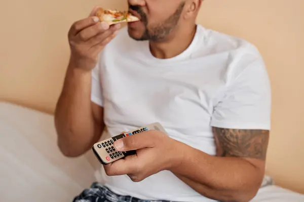 Sluiten Van Getatoeëerde Man Eten Pizza Thuis Houden Afstandsbediening Terwijl — Stockfoto