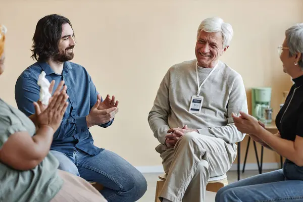 Group Smiling Senior People Applauding White Haired Man Sitting Circle — Stock Photo, Image