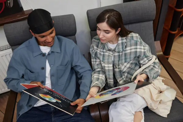 Müzik dükkanında plak dinleyen ve sandalyelerde uzanan genç bir çiftin en iyi manzarası.