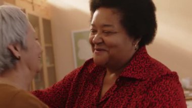 İki farklı eski dostu selamlayan orta boy yaşlı zenci kadın akşam yemeği için eve geldi.