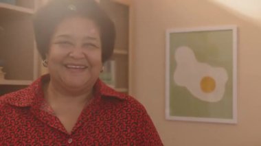 Orta mercekli mutlu yaşlı siyahi kadın gündüz güneşli dairesinde etnik çeşitlilikte birkaç eski arkadaşıyla buluşuyor.