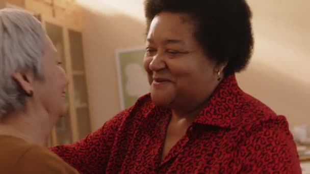 2人の古い多様な友人を迎える喜ばしい黒人女性のミディアムショットは 自宅で夕食のために来ました — ストック動画