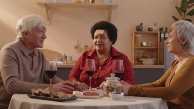 Alnında çıkartma notları olan üç komik çok ırklı son sınıf arkadaşının ev yemeği partisinde tahmin oyunu oynadığı orta boy bir fotoğraf.