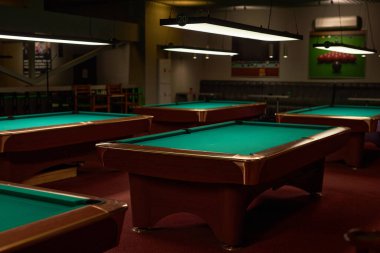 Yeraltı oyun alanındaki birkaç bilardo masasının arkaplan görüntüsü.