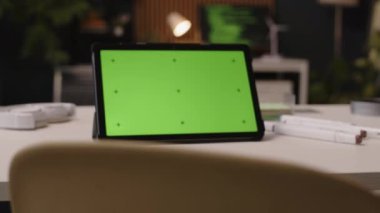 Çağdaş çalışma alanındaki ofis masasındaki dijital tablet üzerinde krom tuşlu yeşil ekran görüntüsü olmayan kişilere yakınlaştır