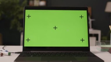 Yakınlaştır. Çağdaş yeşil ofisteki masadaki dizüstü bilgisayarda krom anahtarlı yeşil şablon ekranı çeken kimse yok.