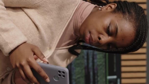 Zoom Arrière Plan Vertical Jeune Femme Noire Naviguant Sur Smartphone — Video