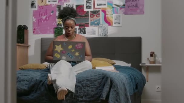 Zeki Genç Siyahi Kadın Rahat Yatak Odasında Duvarında Posterlerle Oturuyor — Stok video