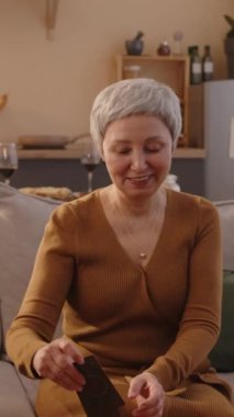 Asyalı son sınıf arkadaşlarının arkadaşlarıyla kağıt oynarken gündüz vakti güzel bir evde kahve masasında otururken çekilmiş dikey bir fotoğrafı.