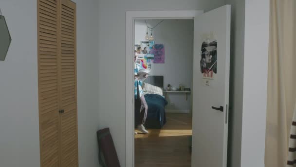 彼女の寝室を出て 近代的なアパートの廊下を歩きながら 明日の試験のための教材を学んでいる白人女性学生のフルショット — ストック動画