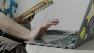 Tanımlanamayan kız lise ya da üniversite öğrencilerinin ders kitabı okuyup hafta sonları evde ders çalışırken dizüstü bilgisayar kullanmaları.
