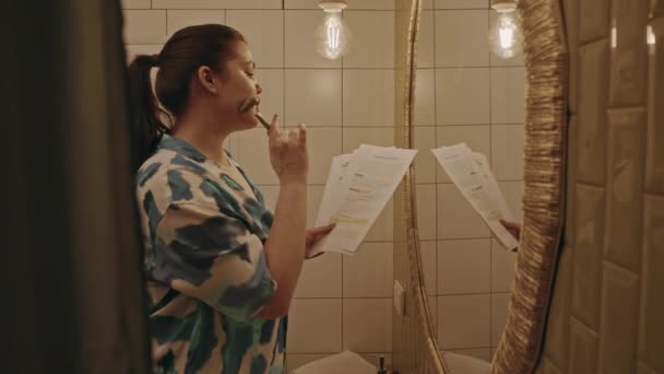 Orta Ölçekli Beyaz Kadın Banyo Aynasının Önünde Elinde Çalışma Materyalleri — Stok video